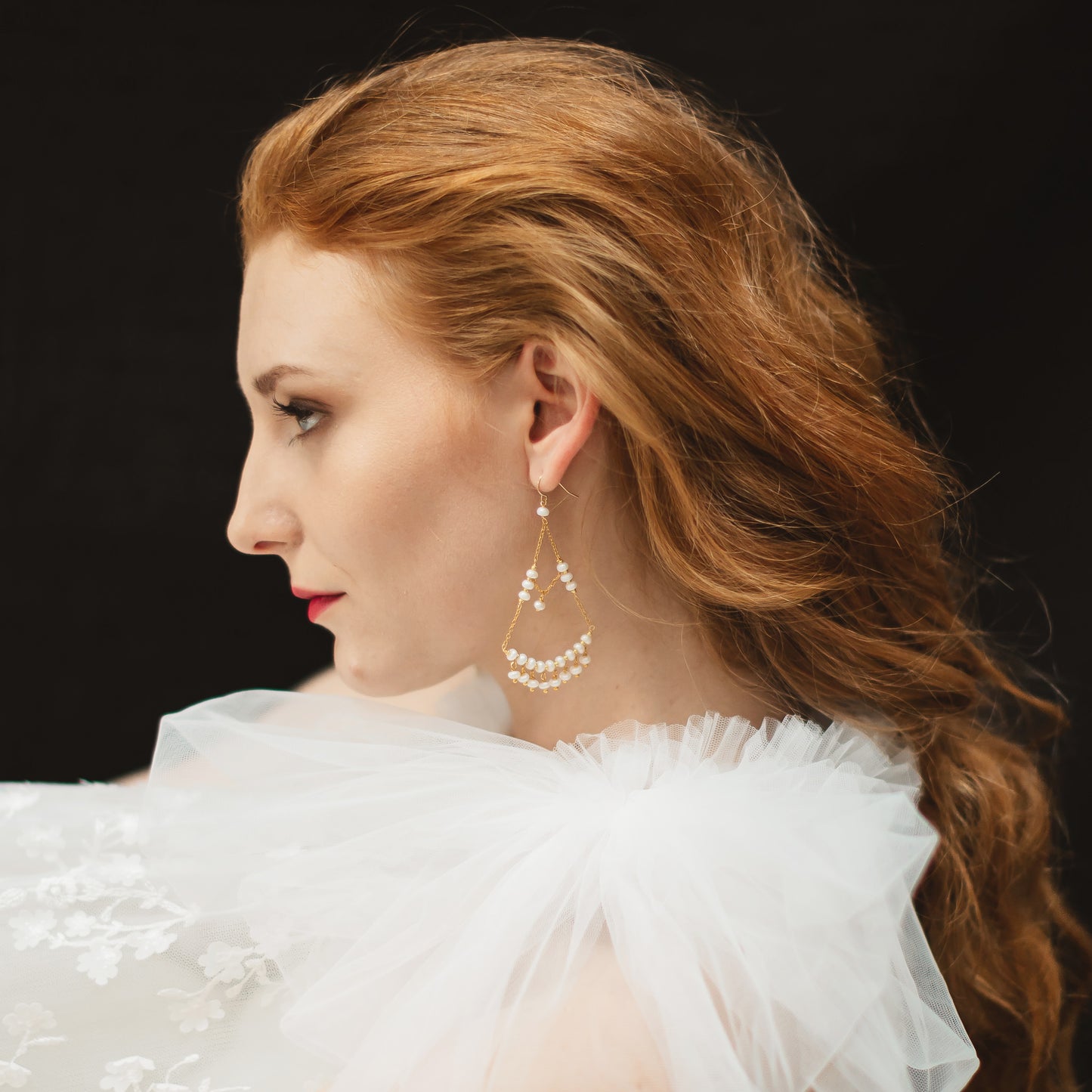 Model wearing pearl gold chandelier earrings designed & handmade by Susie Warner