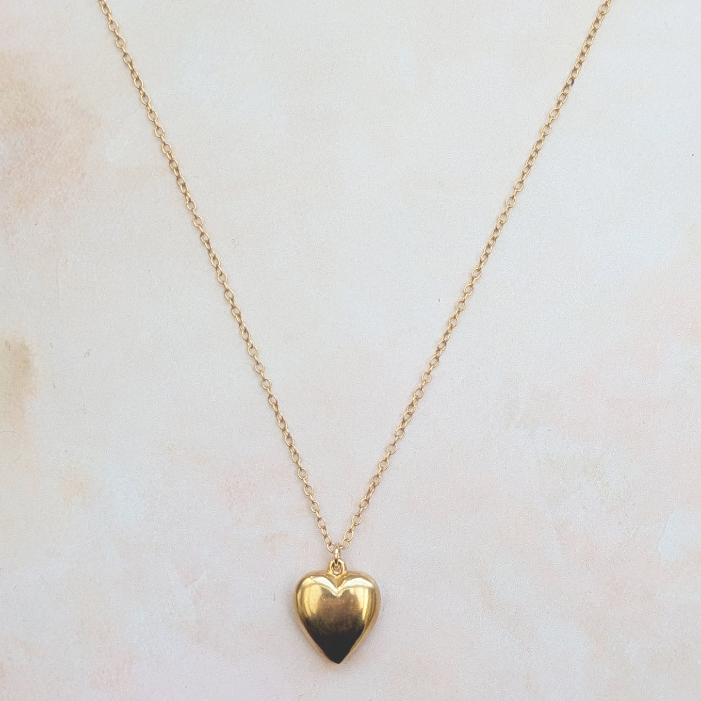 18ct Gold Vermeil heart necklace suspended from a fine chain on a white background.