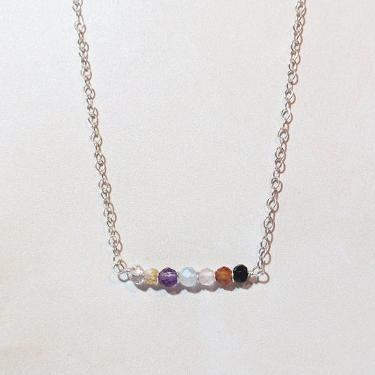 Seven chakra bar necklace on a light background.
