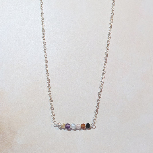 Seven chakra in line necklace on a light background.