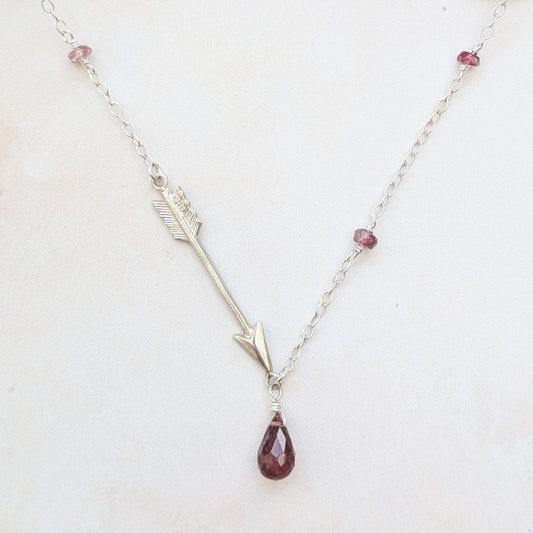 Necklace with a silver arrow pendant and teardrop-shaped Pink Tourmaline gemstone on a white background