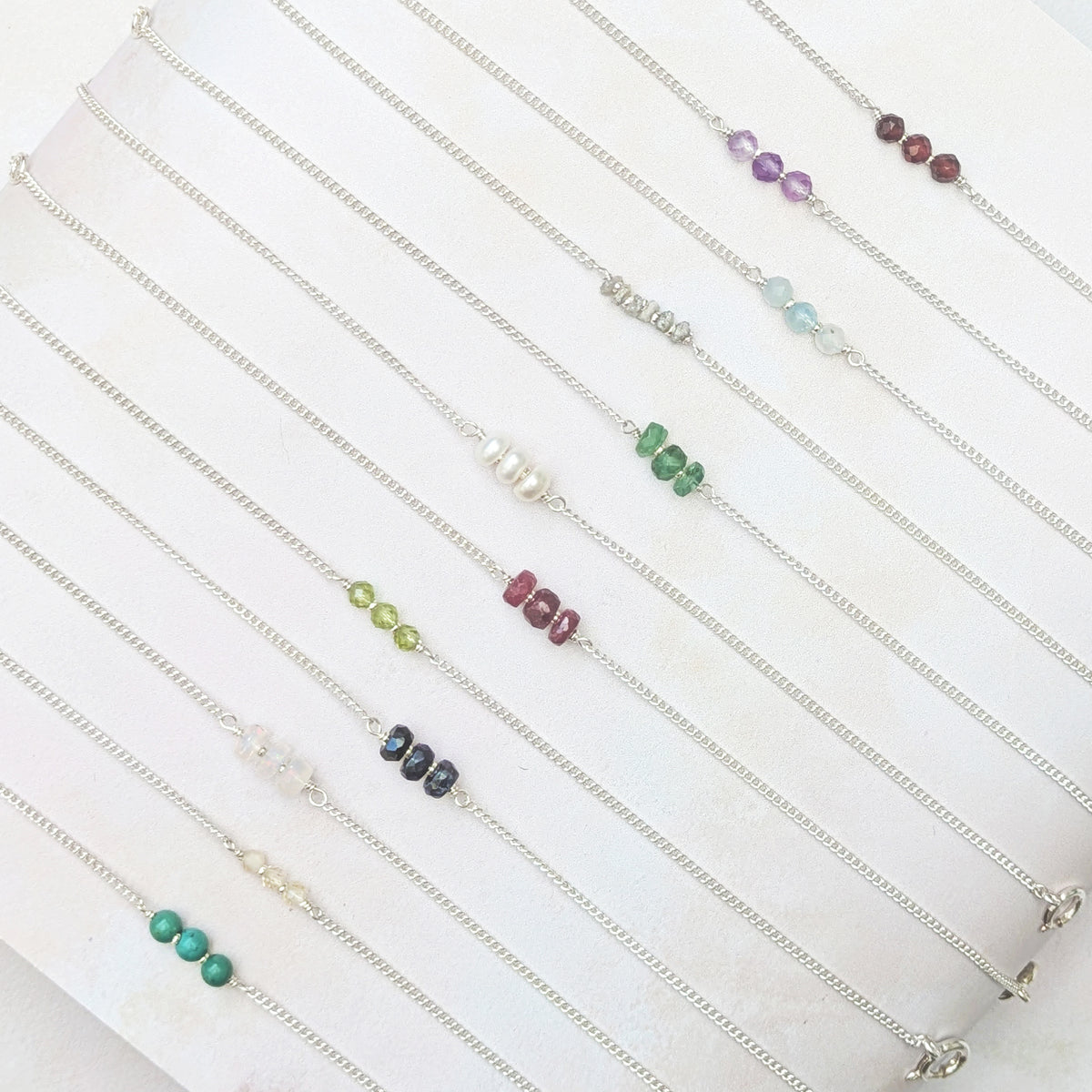 All 12 birthstone bar bracelets shown against a white background.
