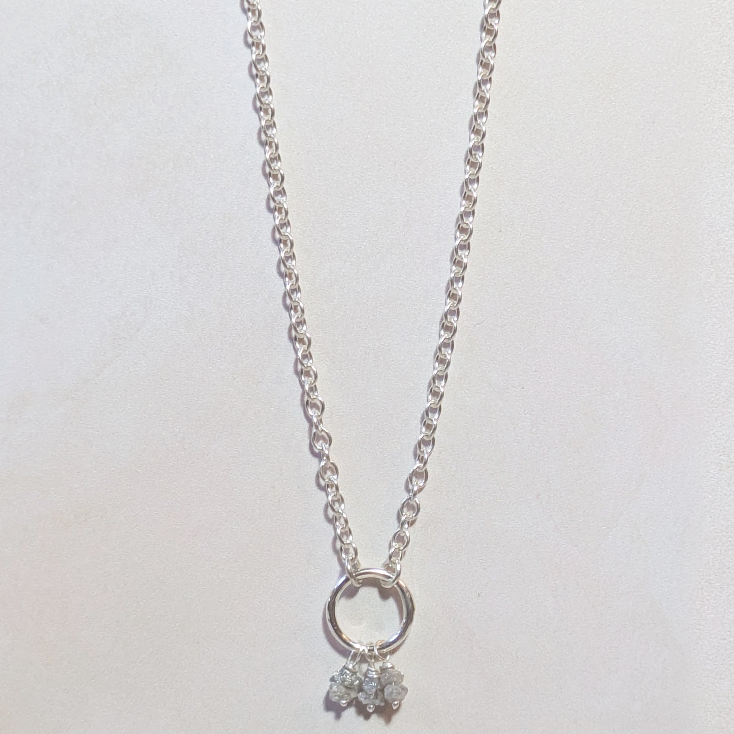 Silver necklace with a small rough Diamond nugget pendant on a white background