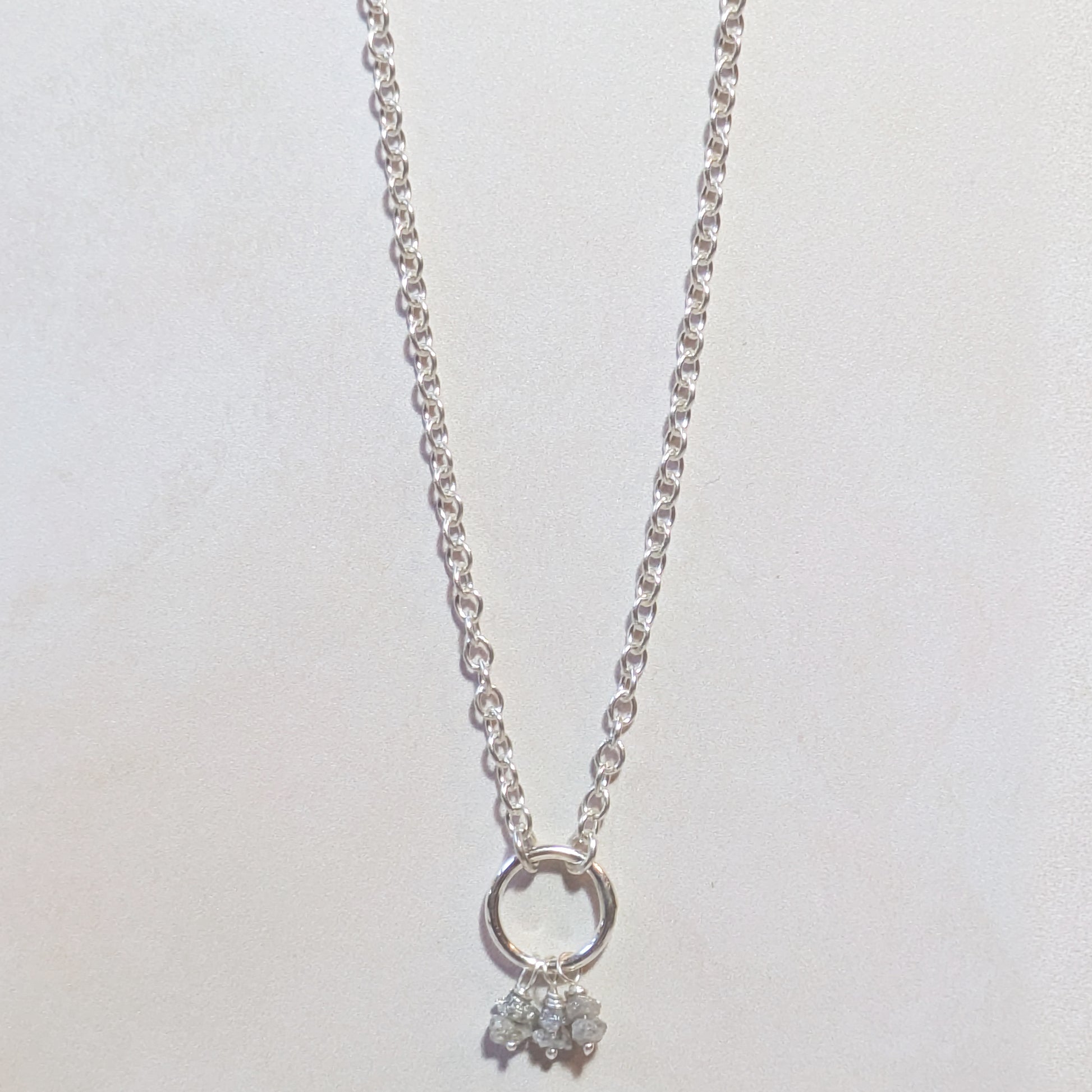 Silver necklace with a small rough Diamond nugget pendant on a white background
