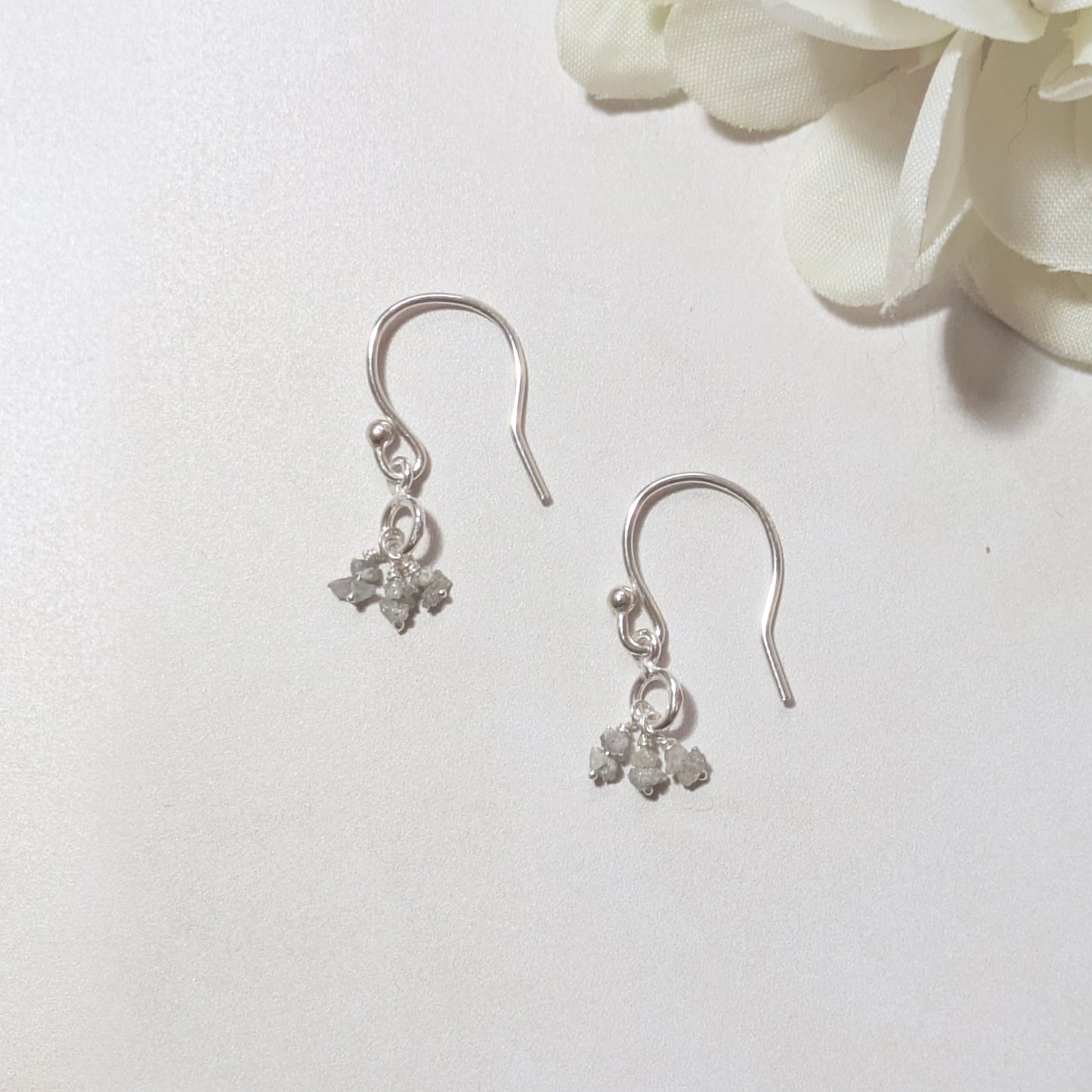 silver drop earrings with natural rough Diamond nuggets on a white background.