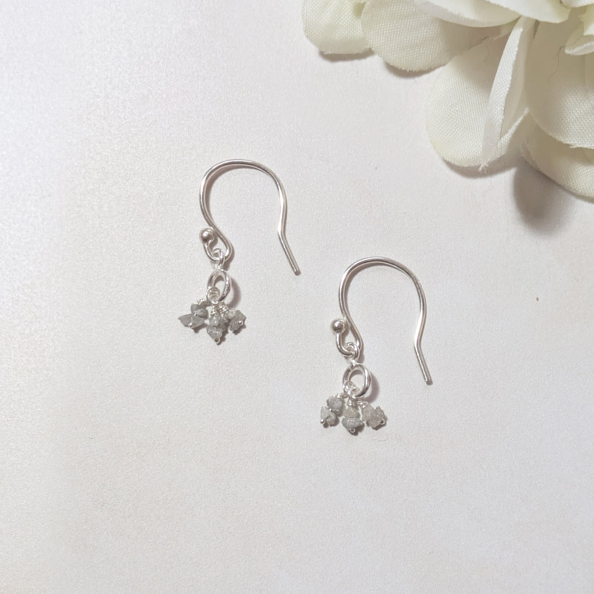 silver drop earrings with natural rough Diamond nuggets on a white background.