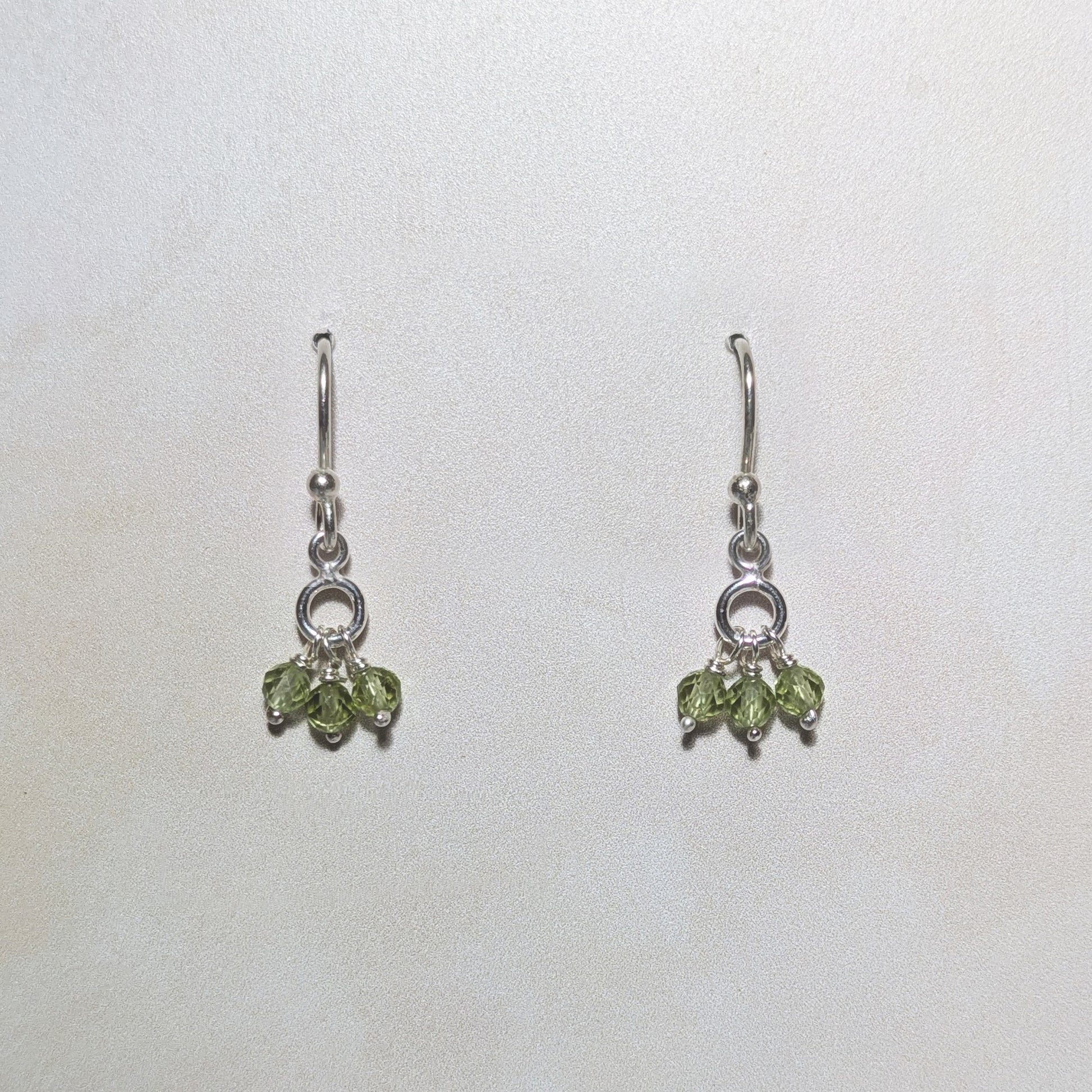 silver drop earrings with Peridot gemstone charms on a white background.