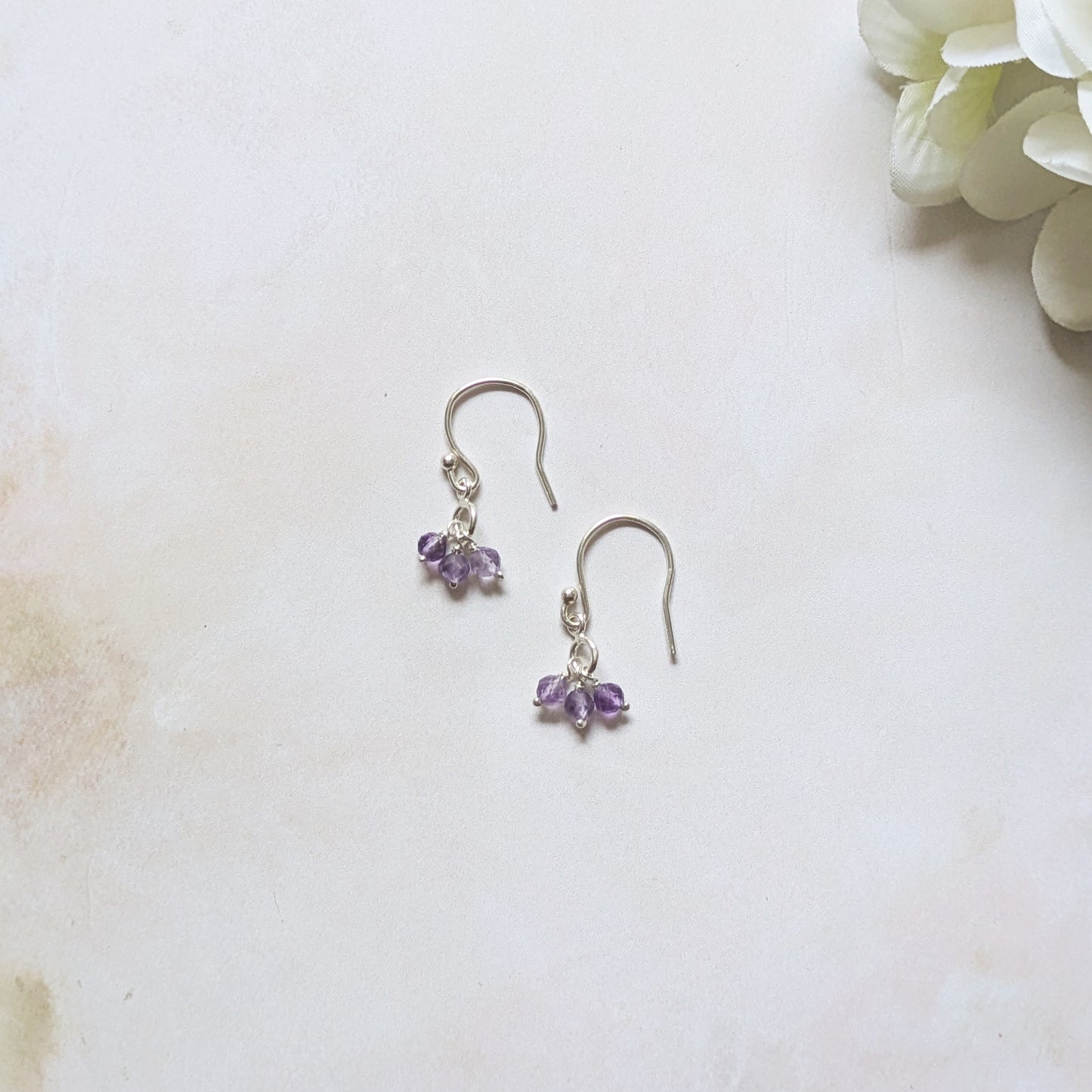 silver hookwire drop earrings with Amethyst gemstone drops against a white background.