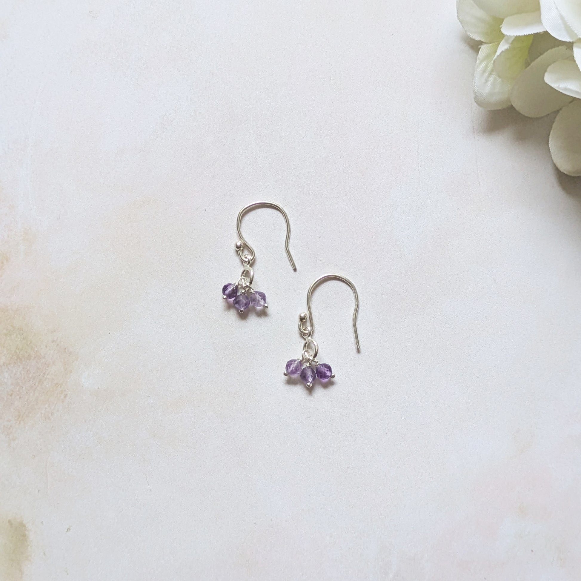 silver hookwire drop earrings with Amethyst gemstone drops against a white background.