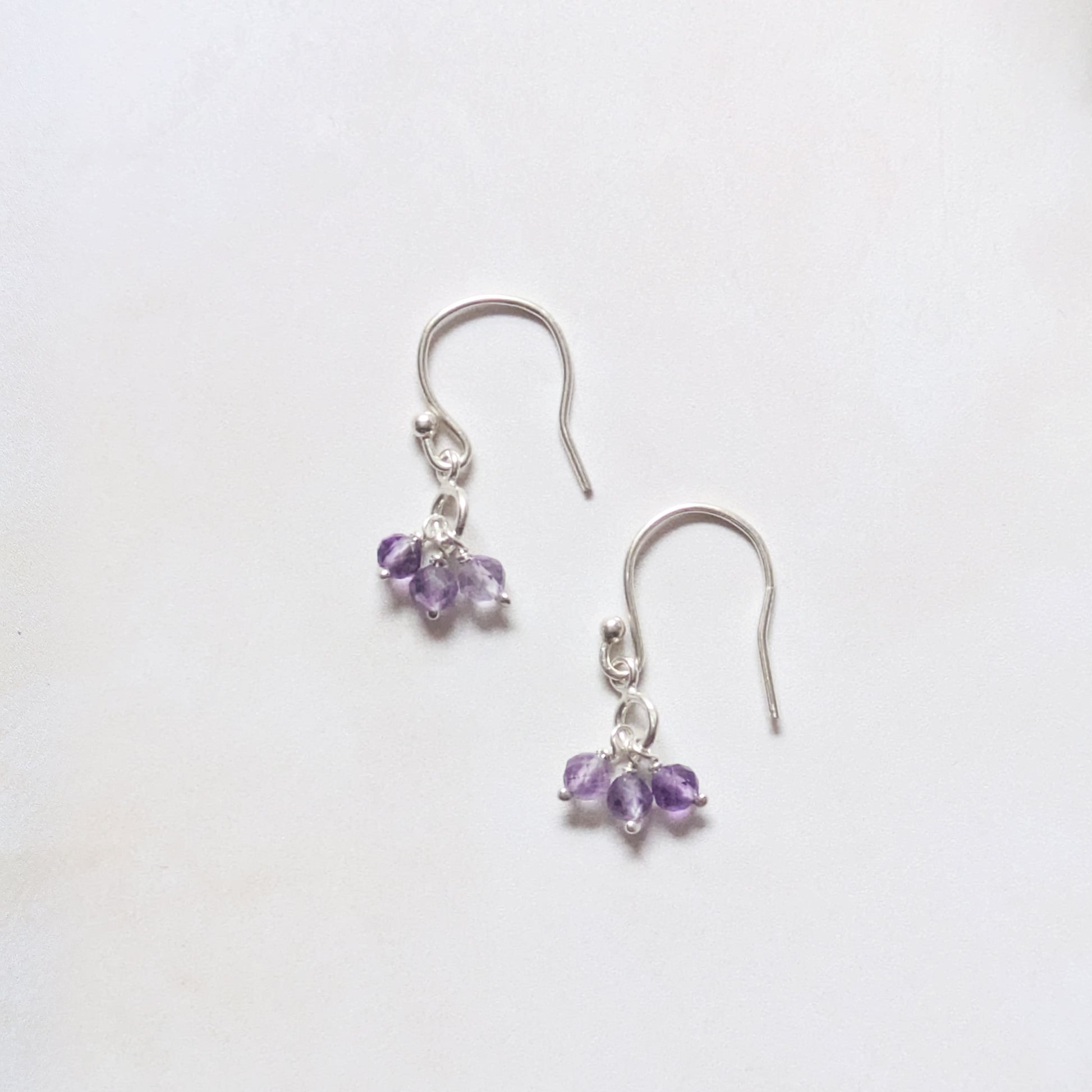silver drop earrings with Amethyst gemstone beads on a white background.