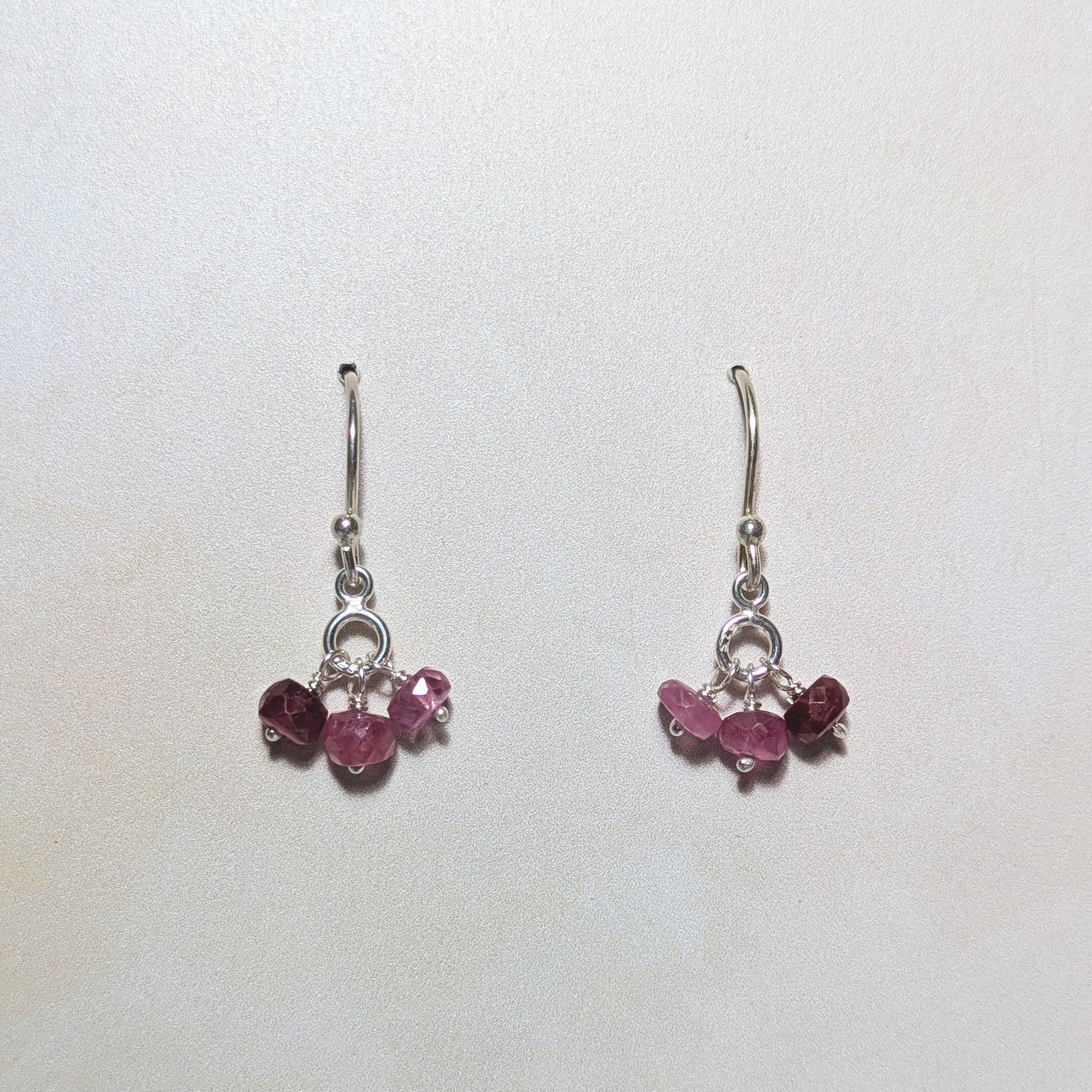 silver drop earrings with Ruby gemstone bead drops on a white background.