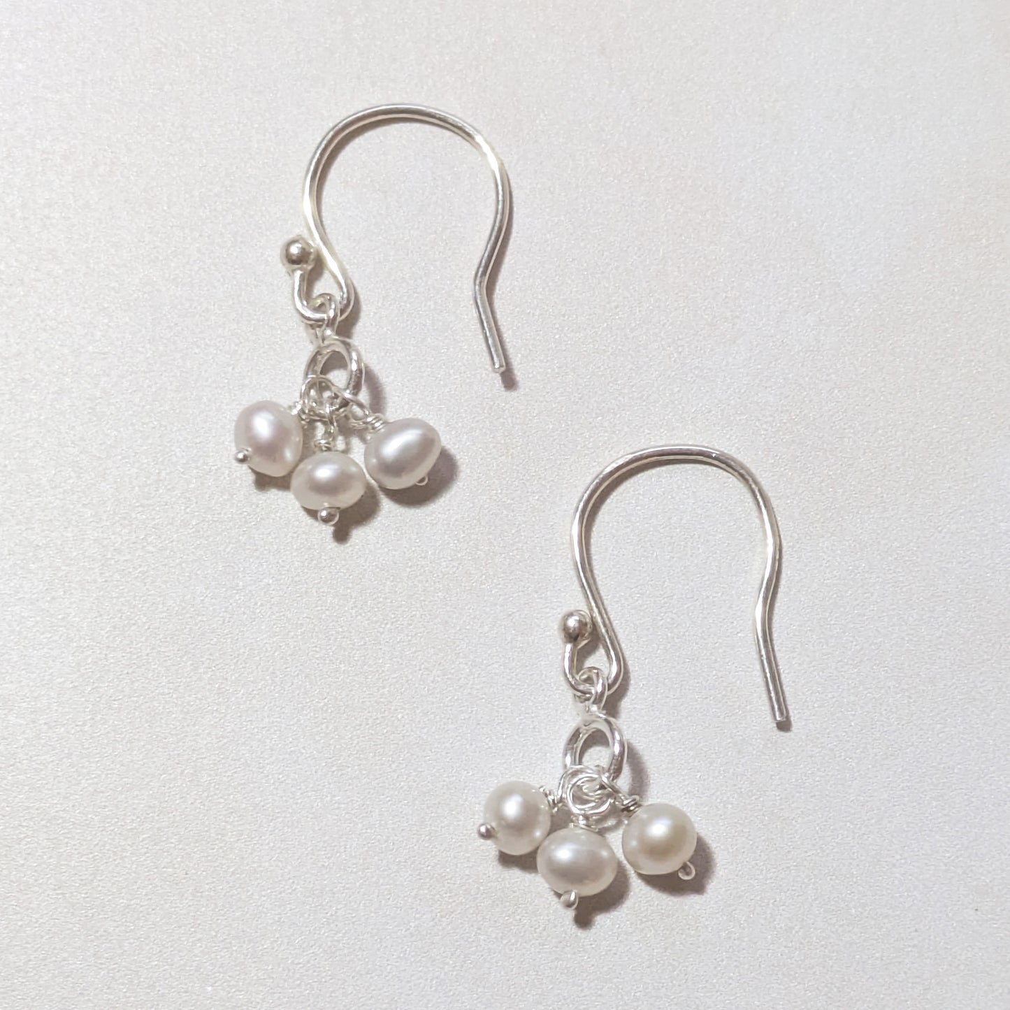 silver drop earrings with pearls on a white background.