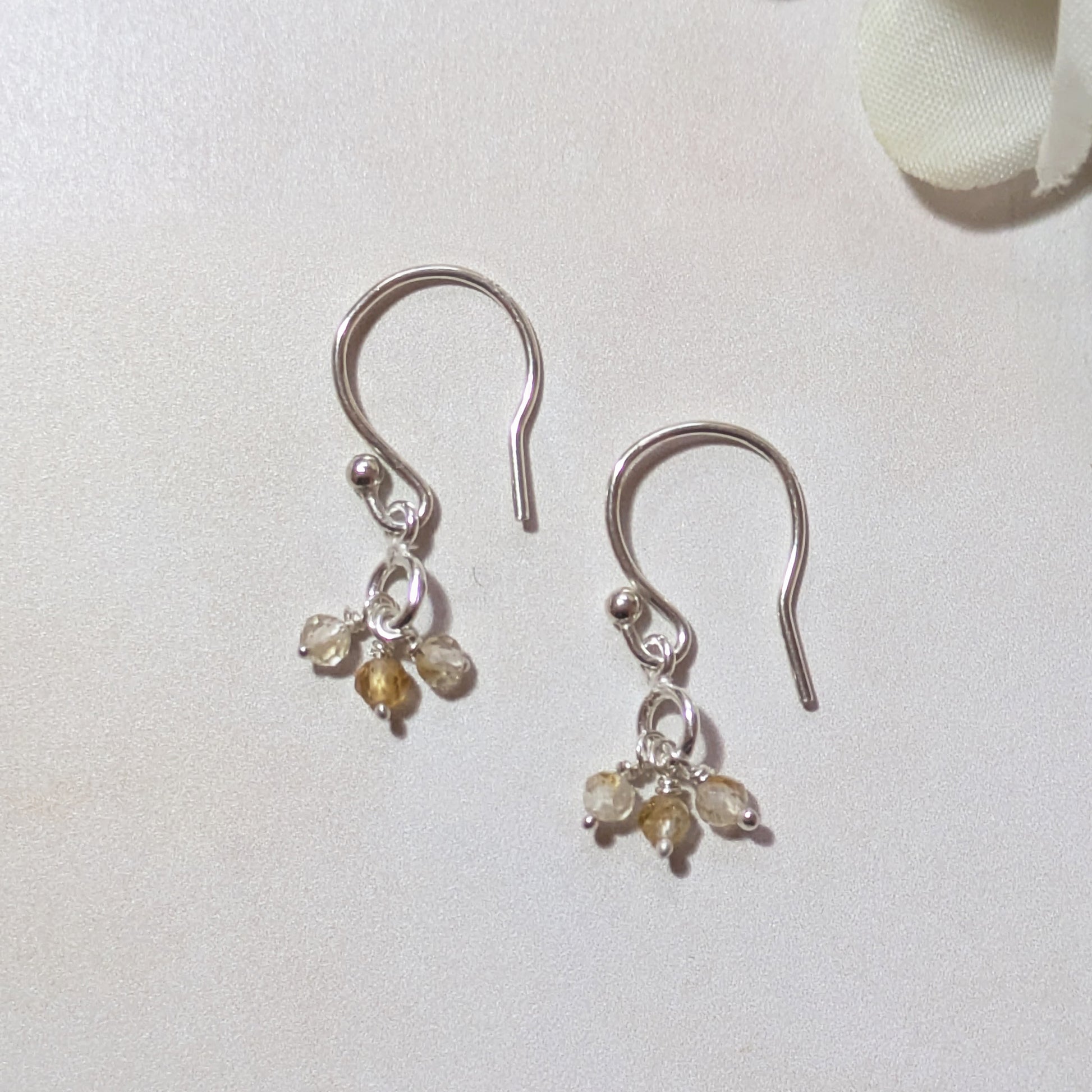 silver drop earrings with mini Citrine gemstone beads on a white background.
