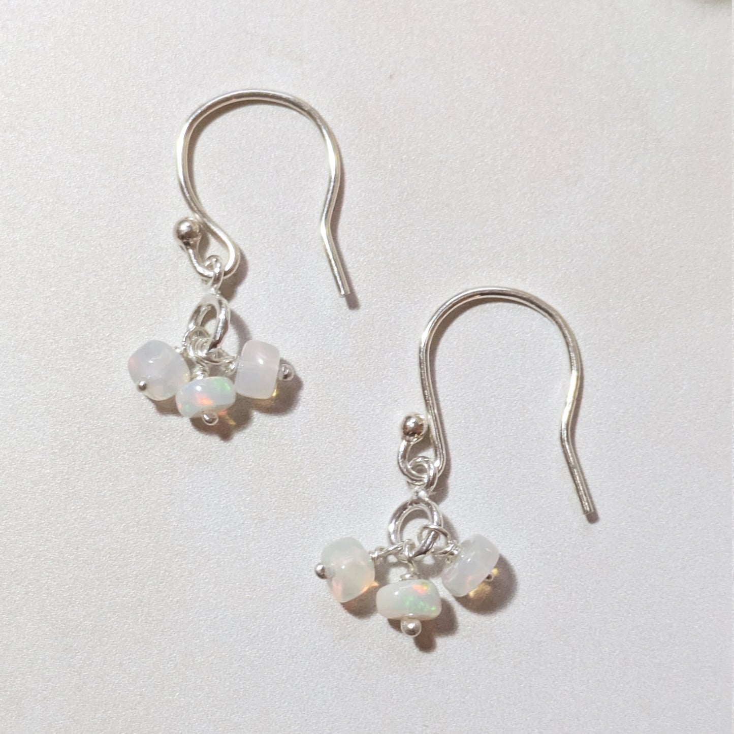silver drop earrings with Opal gemstone beads on a white background.