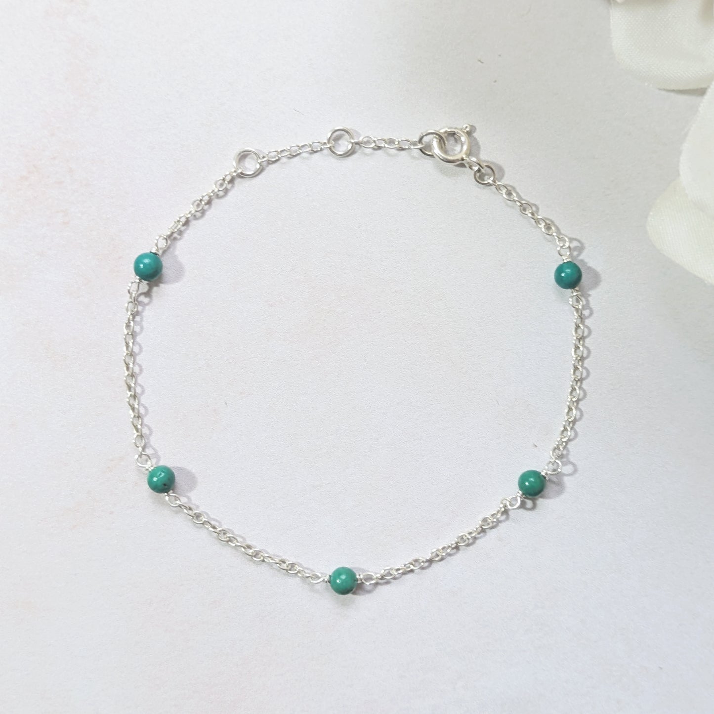 Silver bracelet with natural Arizona Turquoise beads on a white background.