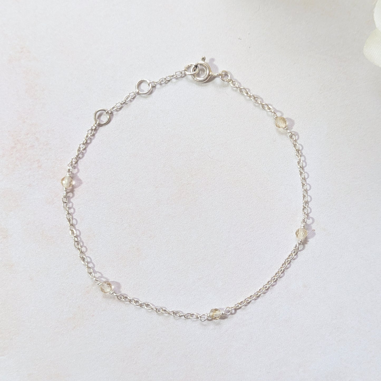Silver bracelet with Citrine gemstone beads on a white background.