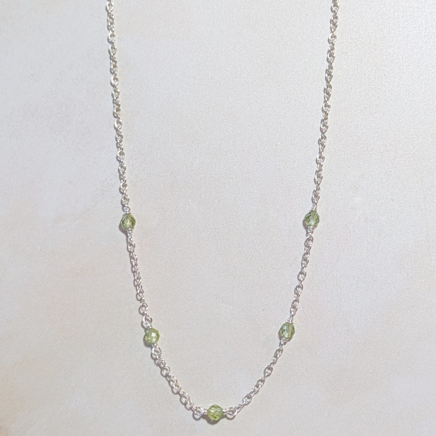 Necklace with Peridot beads on a white background.