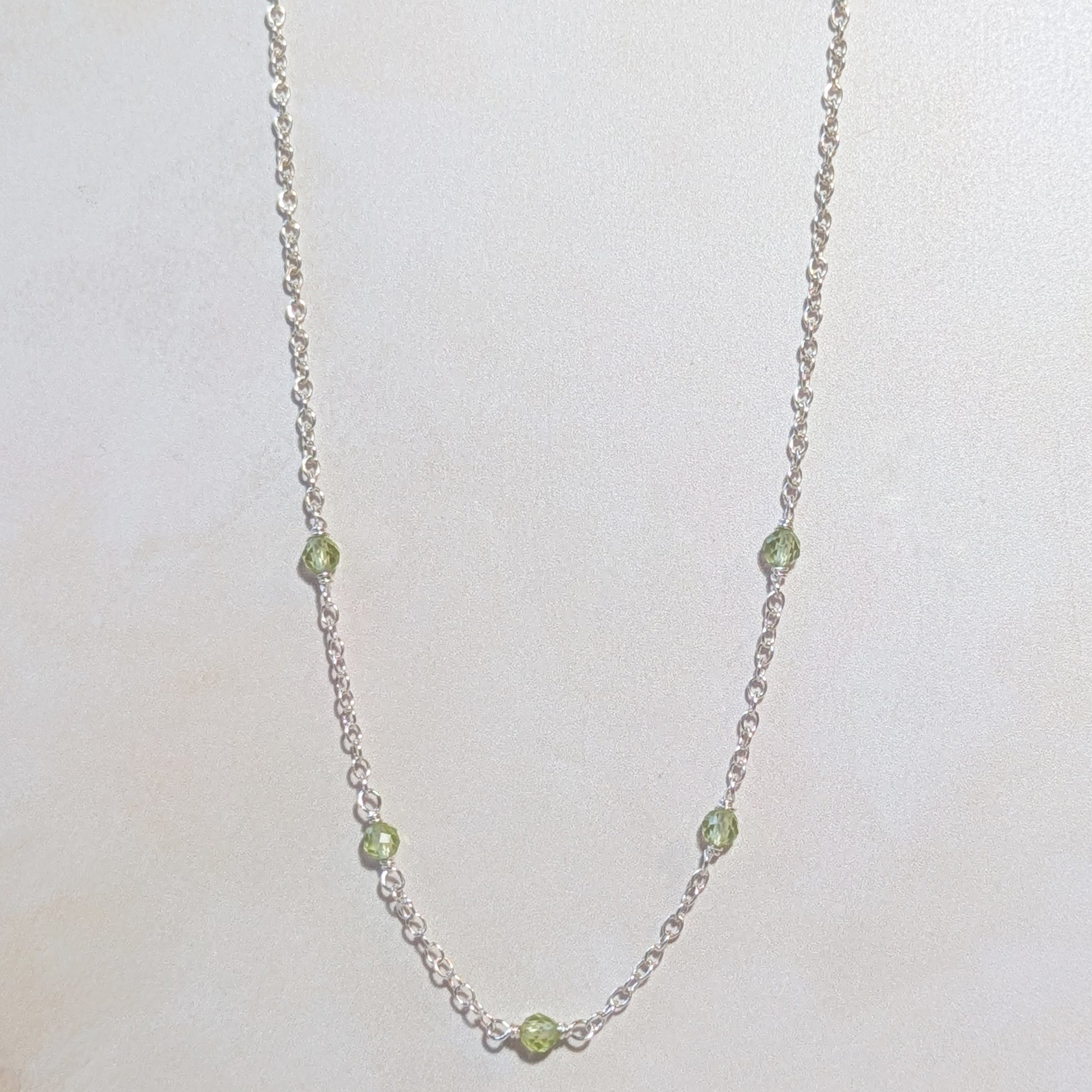 Necklace with Peridot beads on a white background.