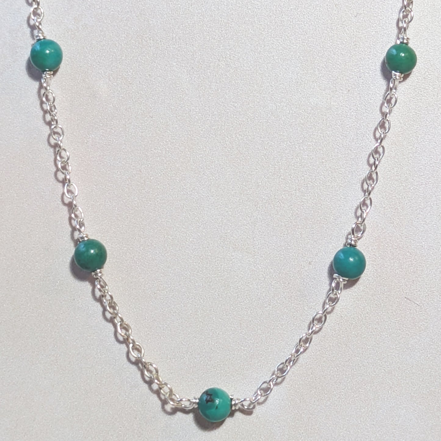 Silver stationed chain necklace with natural Arizona Turquoise beads on a white background.