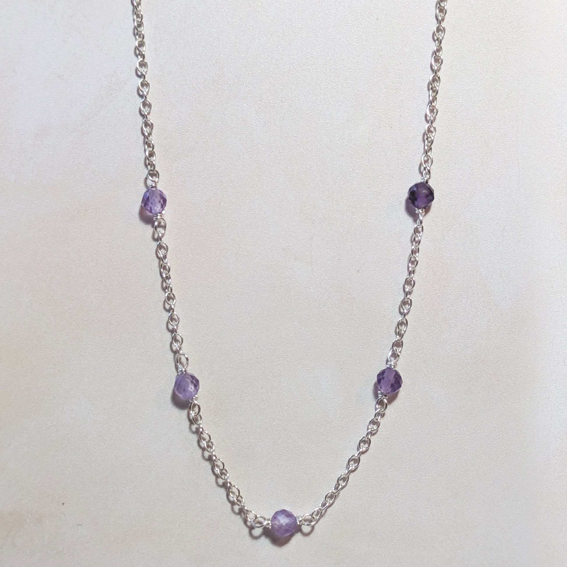 Necklace with Amethyst beads on a white background.