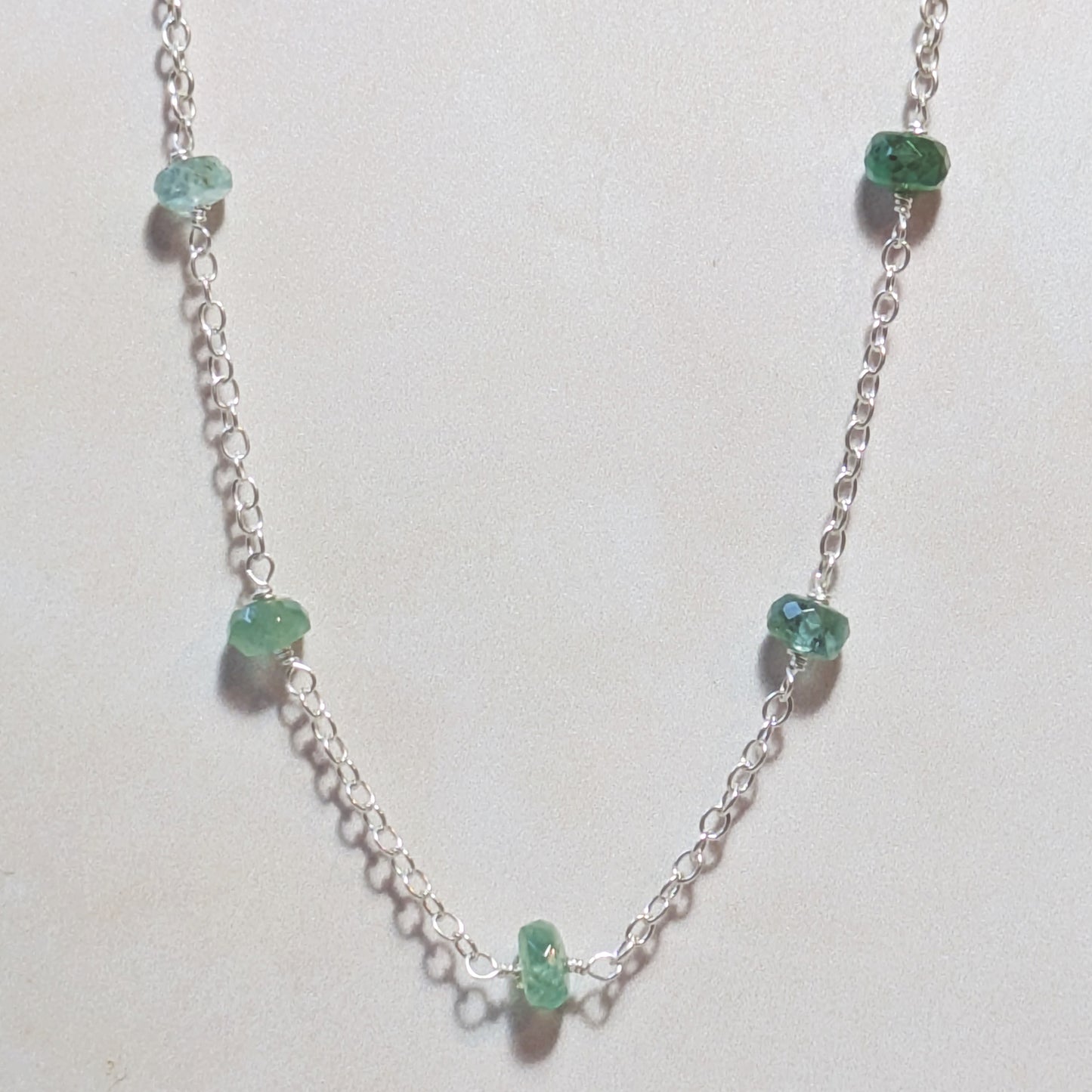 Necklace with Emerald gemstone beads on a white background.