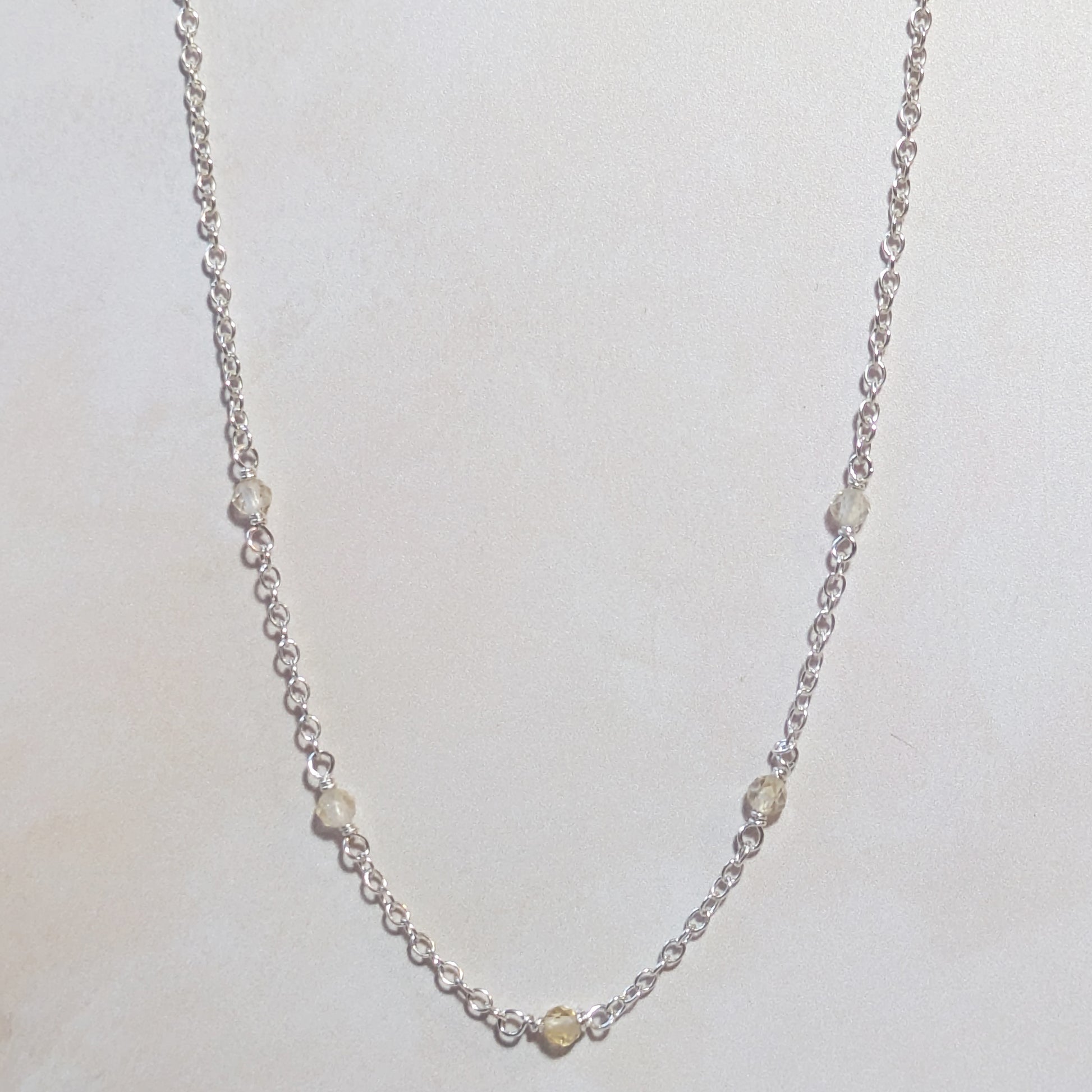 Silver stationed necklace with Citrine gemstone beads on a light background.