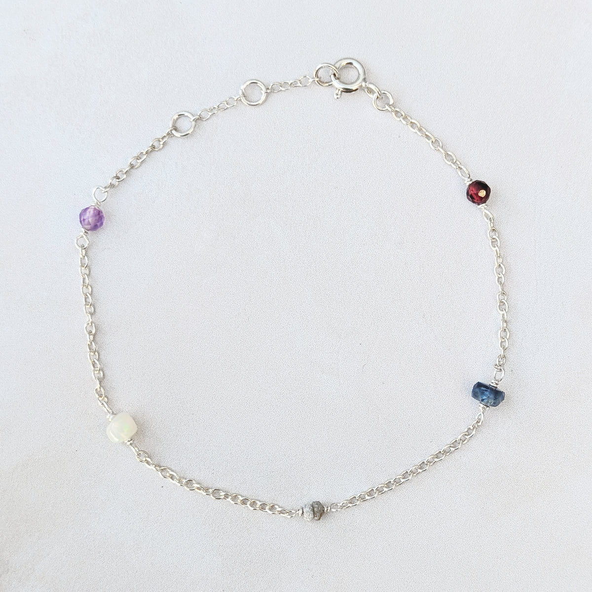 Personalised sterling silver family birthstone bracelet  featuring natural ethically sourced gemstone beads shown on a white background.