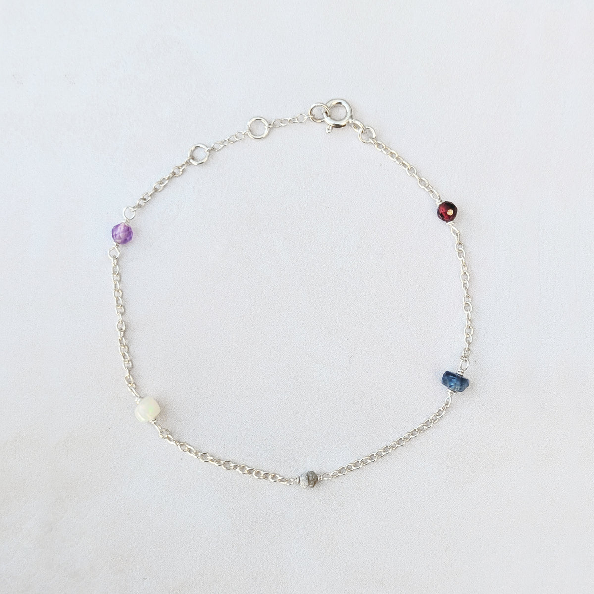 Full view of our personalised recycled sterling silver family birthstone bracelet  featuring natural ethically sourced gemstone beads shown on a white background.