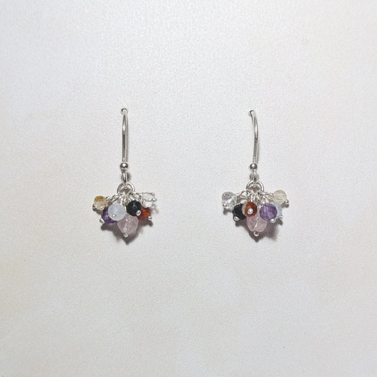 Pair of silver cluster charm earrings with multicoloured gemstones on a white background.